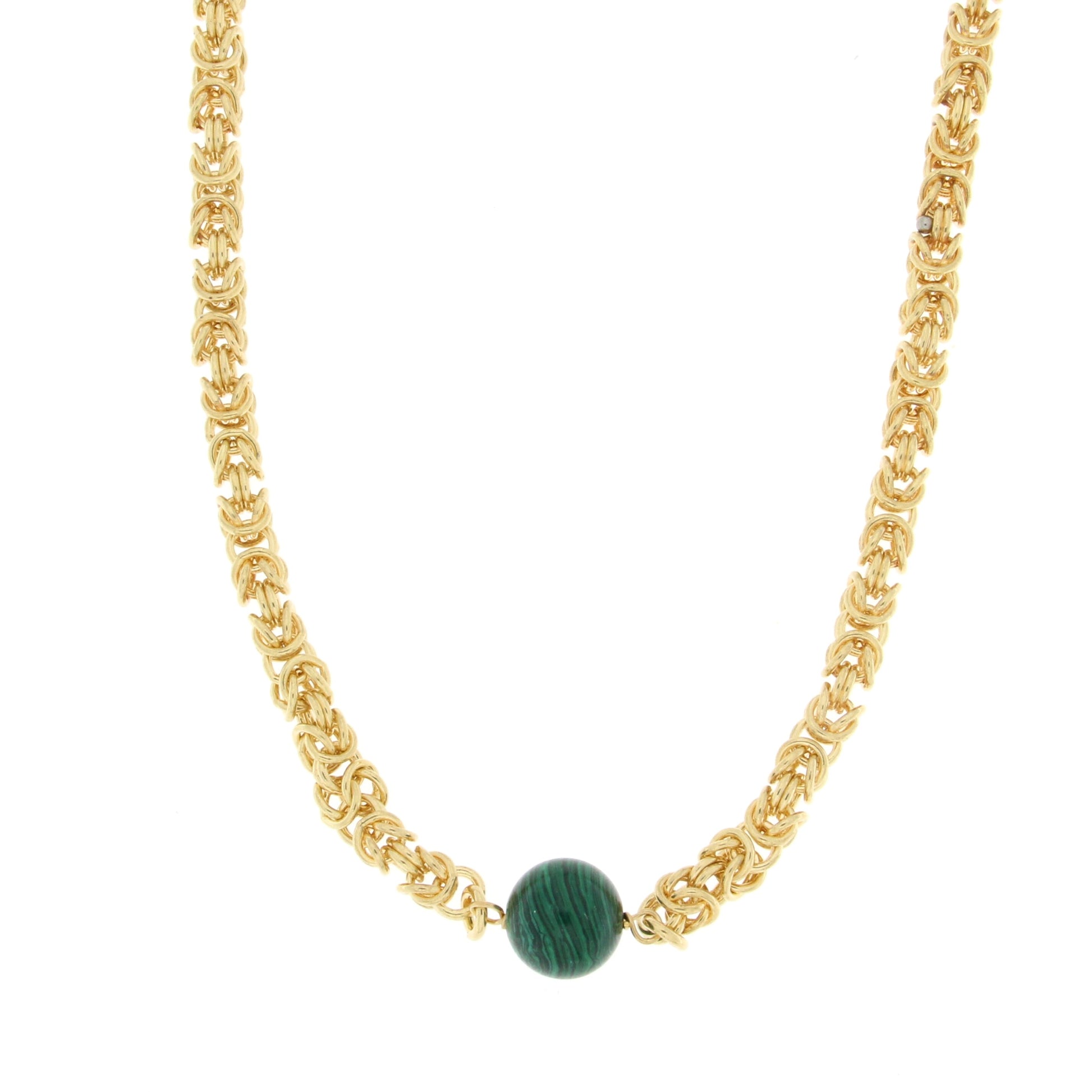 Intricate gold necklace featuring interwoven gold links with a central round green stone for a stylish and vibrant accessory.