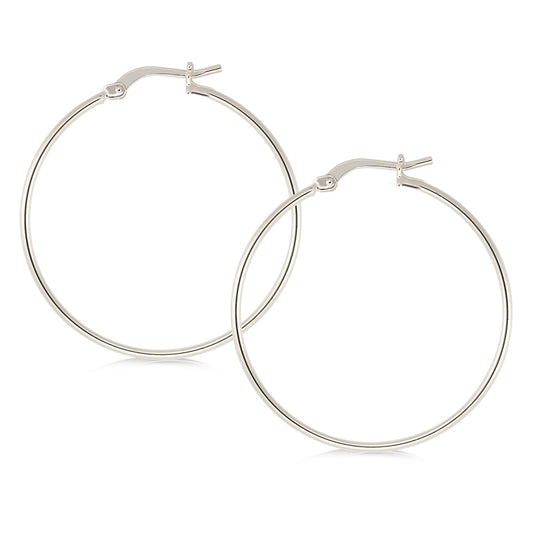 Elegant silver-tone hoop earrings featuring a minimalist design. The hoops are thin and polished, offering a refined and stylish look. They secure with a classic latch closure, making them suitable for both casual and formal occasions.